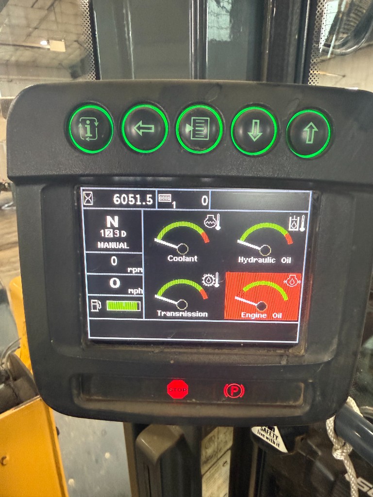 Display, June 2026: 6,051.5 hours (this photo was filed against the skid loader until the September visit matched it to the 544K). Note the engine-oil warning on screen.