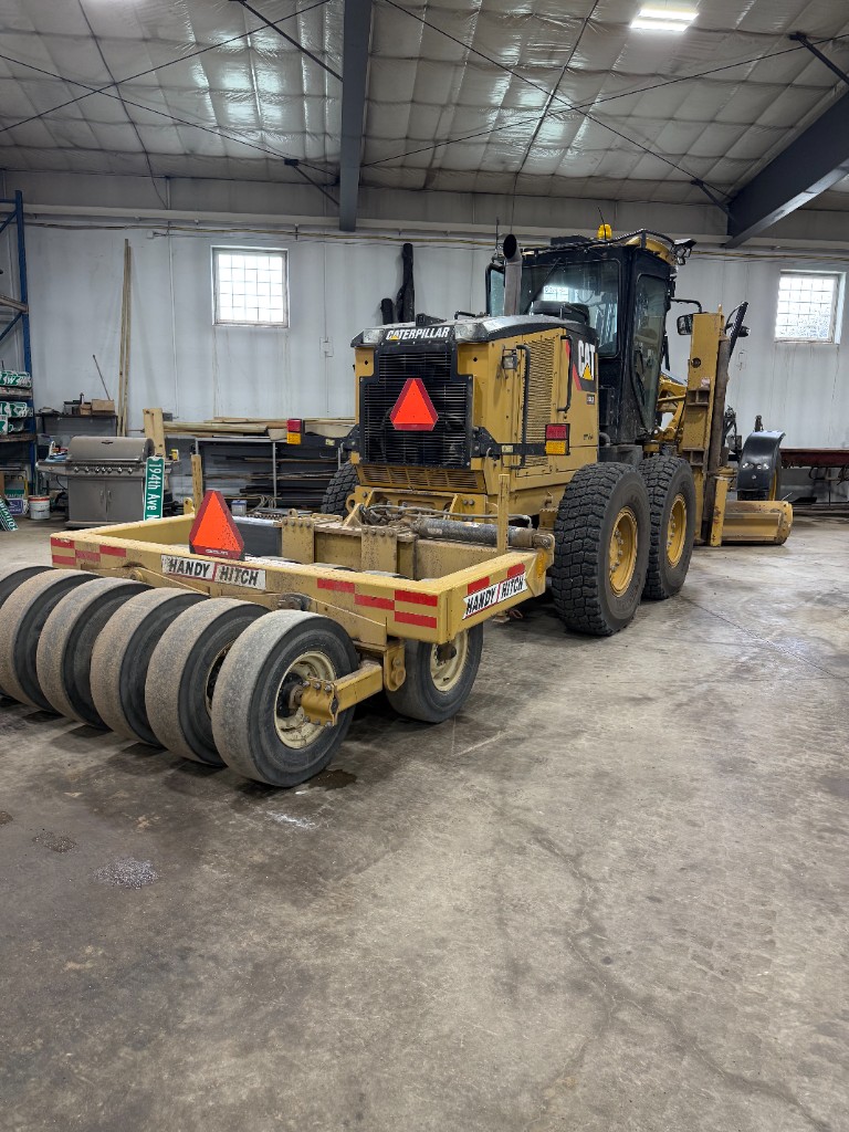 Rear of the grader with the Handy Hitch pneumatic roller hooked up behind it.